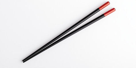 Two black chopsticks with red tips isolated on white background, perfect for Asian cuisine. These elegant utensils add touch of to any dining experience