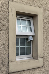 Open Window with Flexible Tumble Dryer Hose Hanging Out to Vent Moist Air and Steam