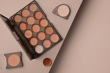 Cream lipsticks in mocha mousse shades on beige background, flat lay. Trendy color of 2025 year