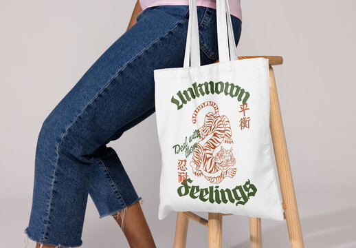 A blank tote bag on a wooden stool, ideal for logo or design customization for events or personal use.