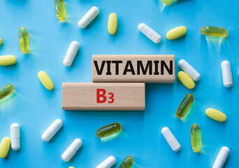 Vitamin B3 symbol. Concept word Vitamin B3 on wooden blocks. Beautiful blue background with pills. Medicine and Vitamin B3 concept. Copy space