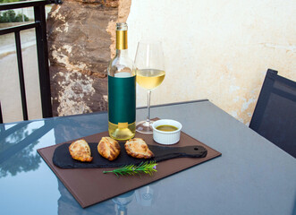 Table set with bottle of white wine, glass, olive oil and empanadas. Table prepared for lunch or dinner with food and drink. Empanadas and wine party time. Fast food lunch. Celebration time.