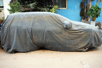 une voiture sous une bâche d protection dans la ville de Dakar au Sénégal en Afrique de l'Ouest