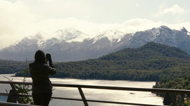 Woman taking pictures of nahuel huapi national lake. tourist viewpoint. 