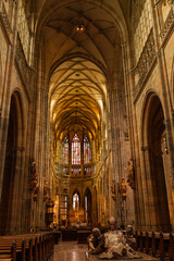 Fototapeta premium Interior of Gothic Cathedral inside. Carved pulpit, stained-glass Windows through which light rays penetrate building Prague, Czech Republic. High quality photo