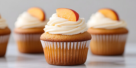 Delicious vanilla cupcakes topped with creamy frosting and a fresh peach slice. Perfect for a summer treat or special occasion.