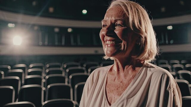 Smiling woman shares her thoughts on performing arts in an empty theater setting
