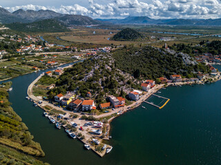 Coastal Village by River surrounded by lush greenery and traditional Mediterranean houses