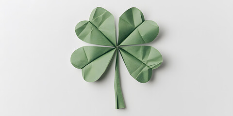 A four-leaf clover crafted from folded paper, a symbol of good luck and fortune.  The delicate green leaves are arranged against a clean white background.