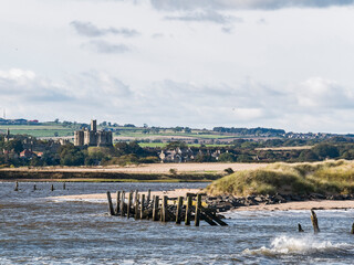 View from river Coquet to Warkworth, Northumberland, UK with medieval castle.
