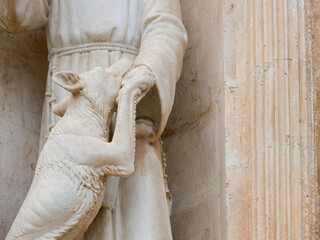 Estatua de santo junto a un perro en una iglesia barroca del sur de Italia