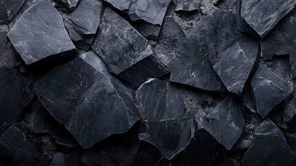 Textured black stone surface with irregularly shaped rock fragments providing a natural background with copy space for text placement.