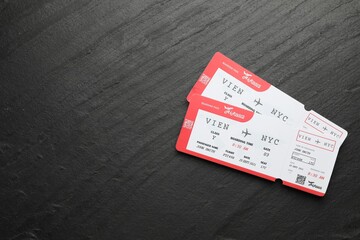 Travel agency. Flight tickets on dark textured table, top view. Space for text