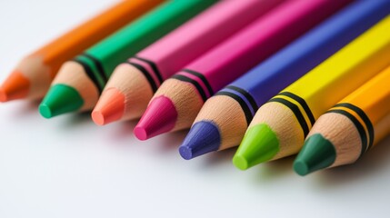 Colorful row of vibrant crayons arranged on white background