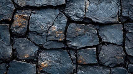 Fototapeta premium Dark textured stone wall with visible cracks and irregular surfaces suitable for background use Copy Space