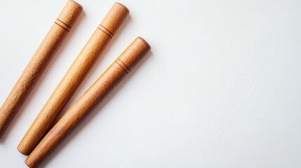 Wooden rolling pins on white background with Copy Space for culinary or baking related themes.