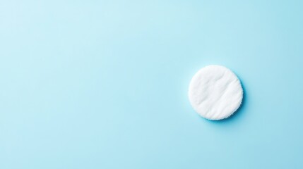 Clean cotton pad on a light blue background with ample copy space for text placement.