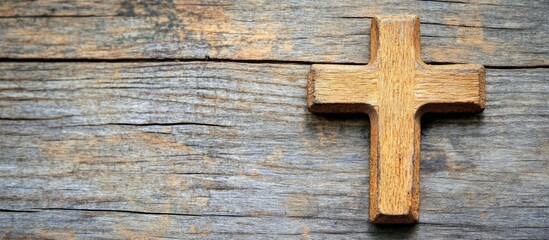 Christian cross pendant on rustic wooden surface with blurred focus and ample space for text or messaging in a spiritual context