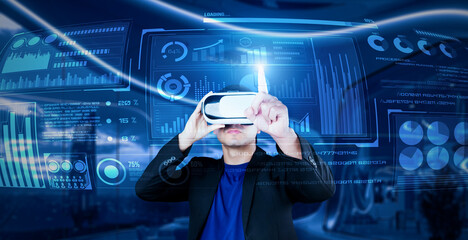 Project manager with VR goggles pointing financial chart and glowing blue light at office. Skilled businessman checking and planning marketing strategy by using data from augmented reality. Ingenuity.