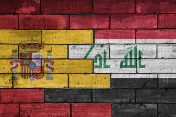 colourful painted big flag of spain and flag of iraq on a massive old brick wall background. concept