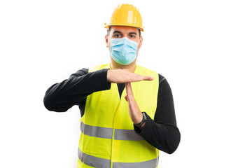 Fototapeta premium Builder wearing medical or surgical mask making timeout gesture