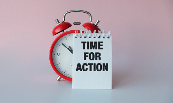 Time For ActionInscription on a notebook near a red alarm clock on a light background