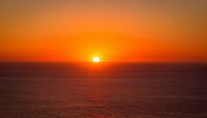 Obraz premium 멀리 수평선 위로 떠오르는 선명한 일출, 붉고 따뜻한 색감의 태양