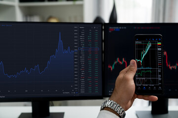 Trader businessman searching on smartphone, analyzing in dynamic stock exchange investment screen...