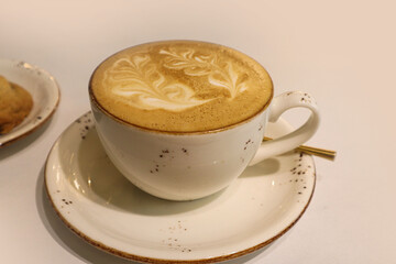 Drawing on coffee in a white cup, close-up