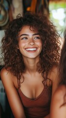 Fototapeta premium Smiling woman with curly hair and glasses engages in conversation at a social gathering in a modern setting