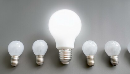 일렬로 나란히 정렬된 여러 개의 하얀 전구 중 하나만 빛을 밝히고 있는 모습