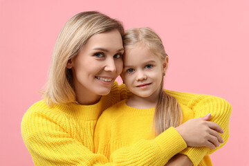 Cute little girl with her mom on pink background. Happy Mother's Day