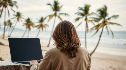 A person working remotely on a laptop by the beach with palm trees and a beautiful ocean view
