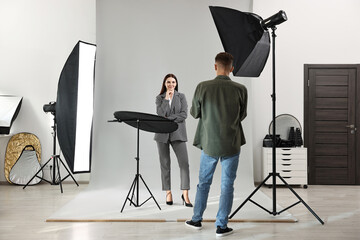 Photographer working with model in professional photo studio