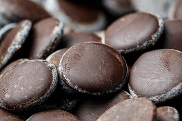 Background and texture dark chocolate chips, closeup. Chocolate pieces for dessert decoration
