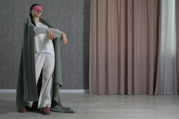 Young woman suffering from sleepwalking at home, space for text