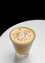 Creamy Raf coffee in a glass, topped with frothy foam, crushed nuts, and whipped cream. A luxurious and aromatic beverage perfect for cozy menus or promotional food photography.