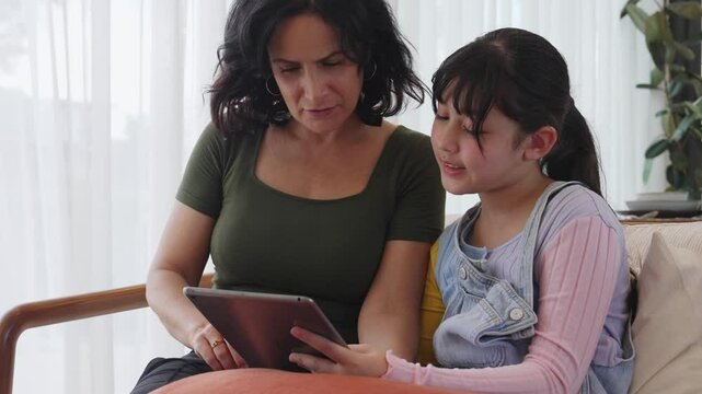 Granddaughter guide grandmother how to use touch screen control tablet. Senior adapt to technology activity communicate new generation kid cross generation gap strengthen family bond. Divergence.
