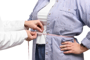 Weight loss. Nutritionist measuring patient's waist with tape on white background, closeup