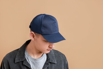 Man in stylish baseball cap on beige background. Mockup for design
