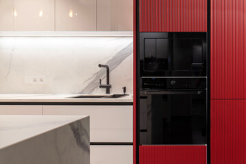 Modern black built-in microwave and oven in a red kitchen