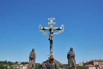 Statuary of the Holy Crucifix and Calvary mounted to the balustrade of Charles Bridge in Prague,...