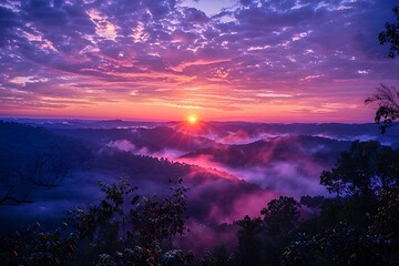 Obraz premium A breathtaking sunrise paints the sky with vibrant purples, pinks, and oranges. Misty mountains stretch into the distance, creating a magical, serene landscape.