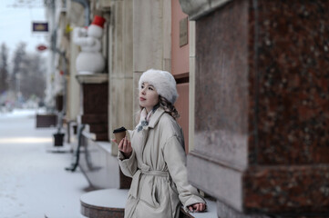 Fototapeta premium A girl walks through a city decorated for Christmas in winter