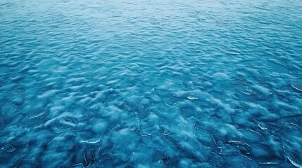 Obraz premium A serene, shimmering blue ocean surface, gently rippling under the light, creating a tranquil atmosphere.