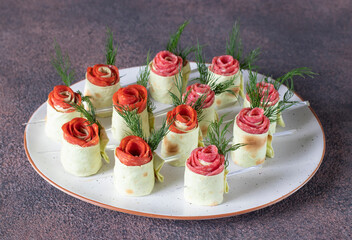 Lavash roses with cream cheese, sausage chorizo and salami on white plate. Appetizer for Valentine's Day, Mother's Day or birthday