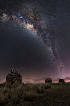 Inca chullpas at sunset with a sky full of stars and the center of the Milky Way in the Andes mountain range