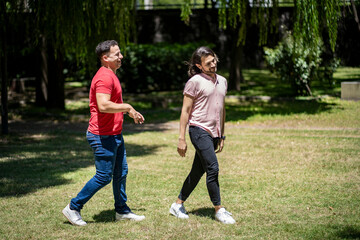 Fototapeta premium Couple of friends walking in a park with very funny faces