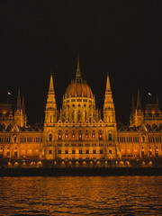 Obraz premium Beautiful photograph of the Hungarian Parliament Building in Budapest at night, illuminated against the dark sky. 