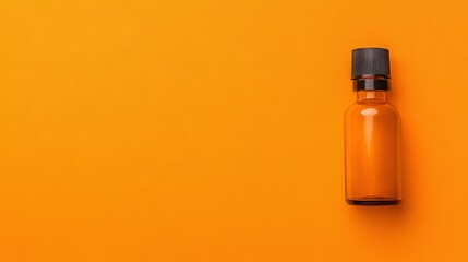   An orange bottle with a black cap on a yellow background has a black cap on its top